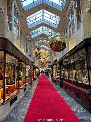 In der Burlington Arcade hängen goldene Weihnachtskugeln von der Decke.