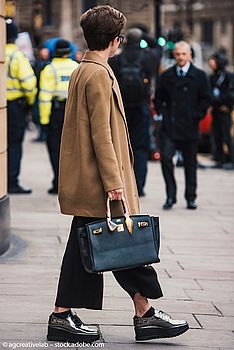 Eine Frau mit Handtasche und Schuhen im Londoner Street Style