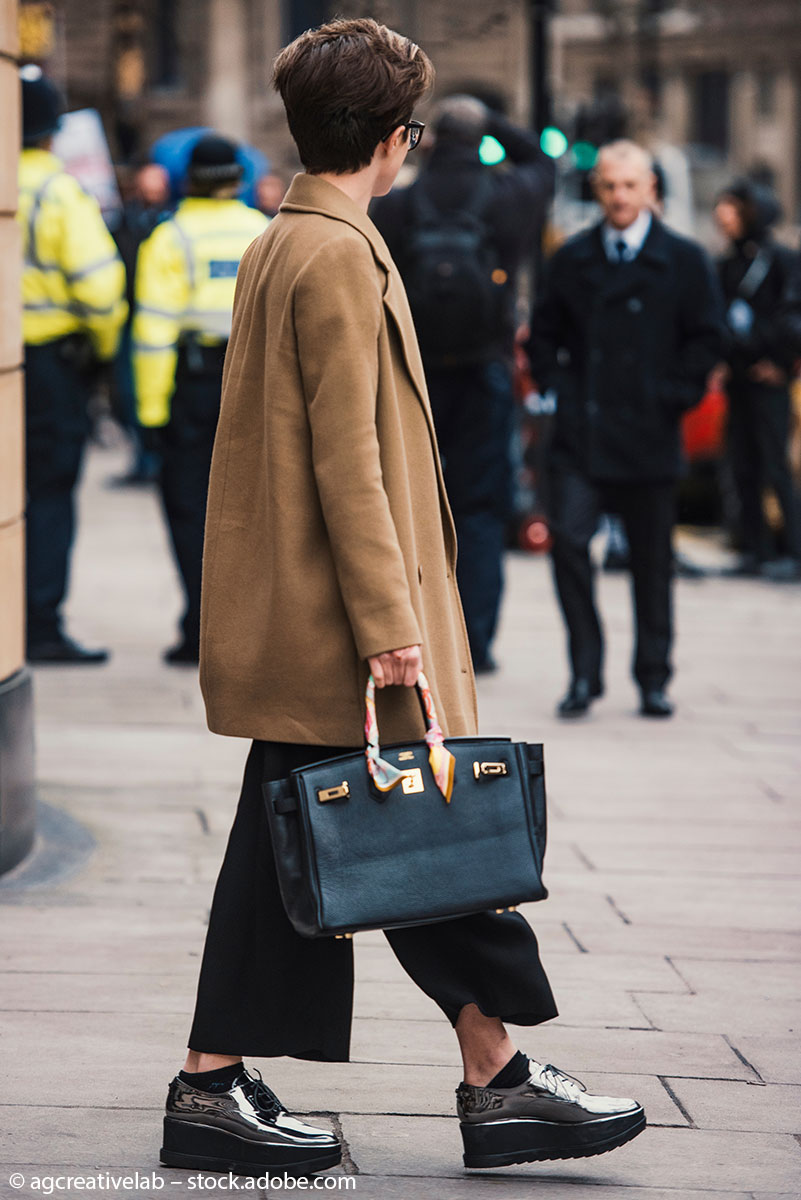 Eine Frau mit Handtasche und Schuhen im Londoner Street Style