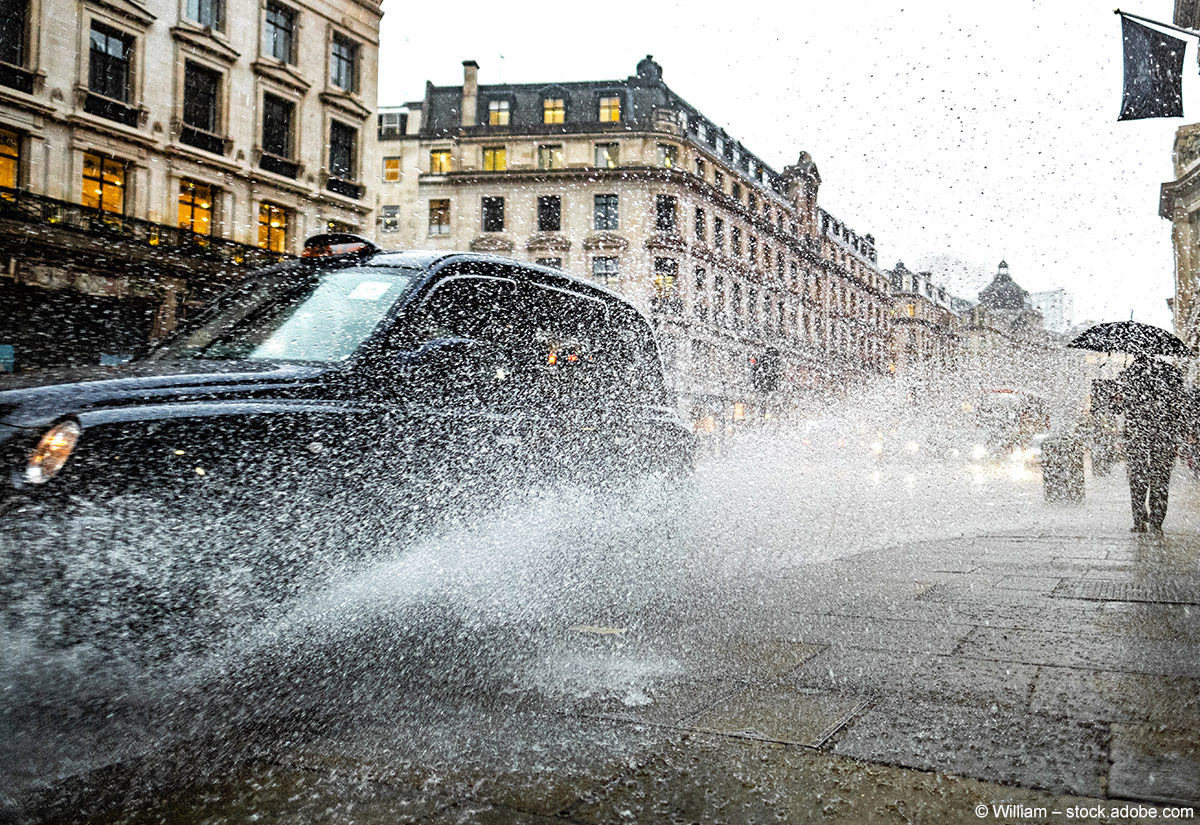 Ein Taxi fährt bei Regenwetter in der Londoner Regent Street durch eine Pfütze.